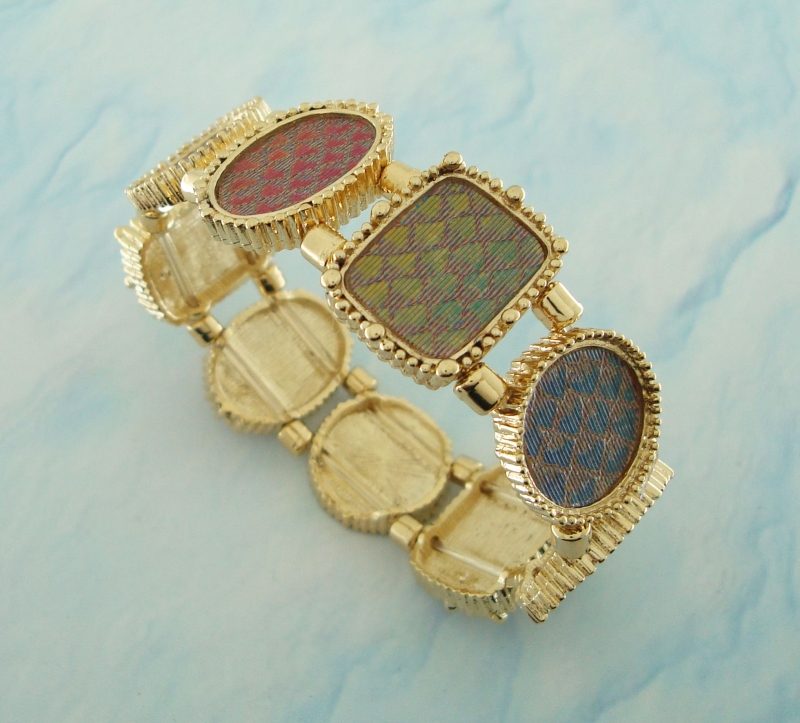 Bracelete dourado com tecido holográfico que muda de cor conforme o angulo de visão.