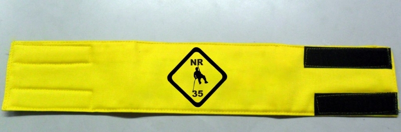 Braçadeira trabalho em altura em brim amarelo com estampa do emblema NR35 em preto. Usada para identificar funcionários que trabalham em alturas. 