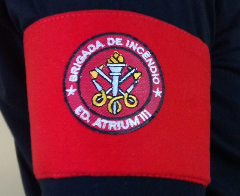 Braçadeira brigada de incêndio personalizada com o nome de sua empresa na parte de baixo do emblema.