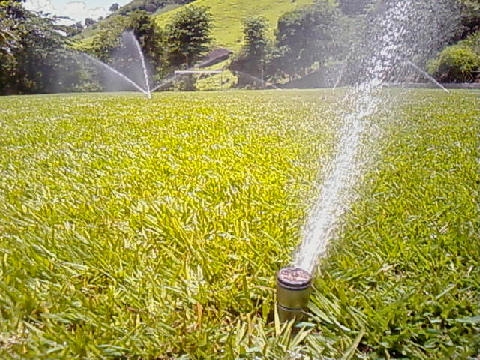 Sistema de Aspersão para campos de futebol. Aspersores submersos na grama e quando acionados chegam a superfície.