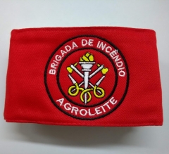 Braçadeira brigada de incêndio personalizada com o nome da empresa na parte de baixo do emblema.